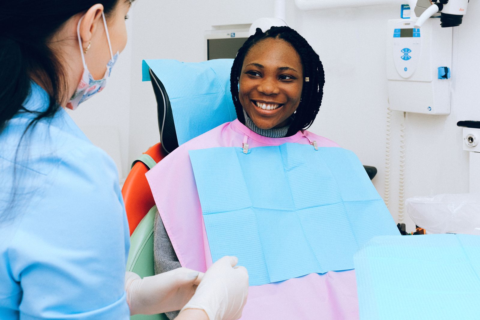 A smiling patient in the dental chair chatting with her hygienist