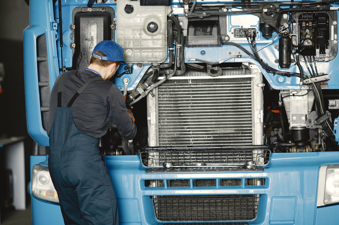 A technician servicing a truck engine