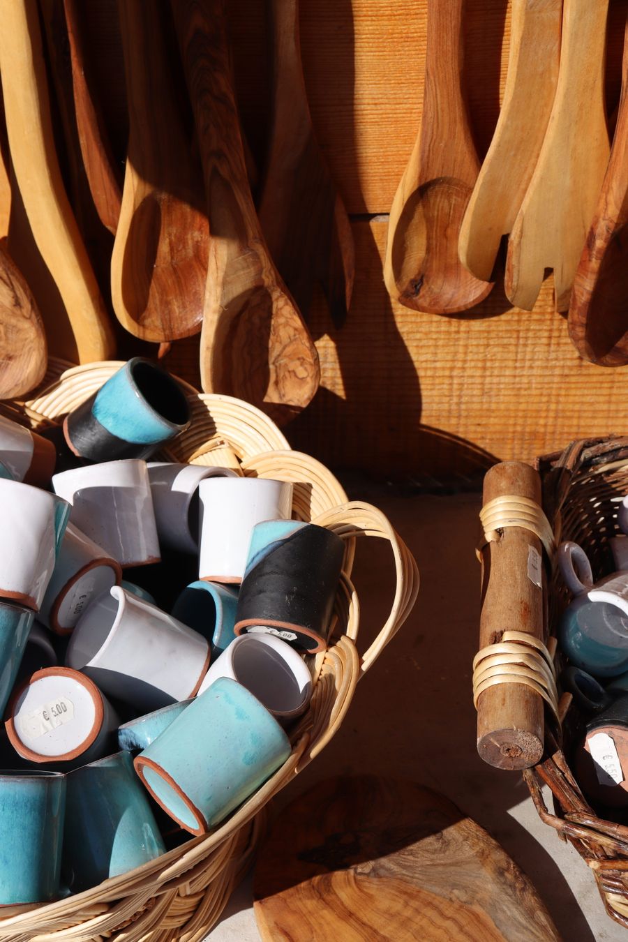 Colorful ceramic mugs beside wooden spoons