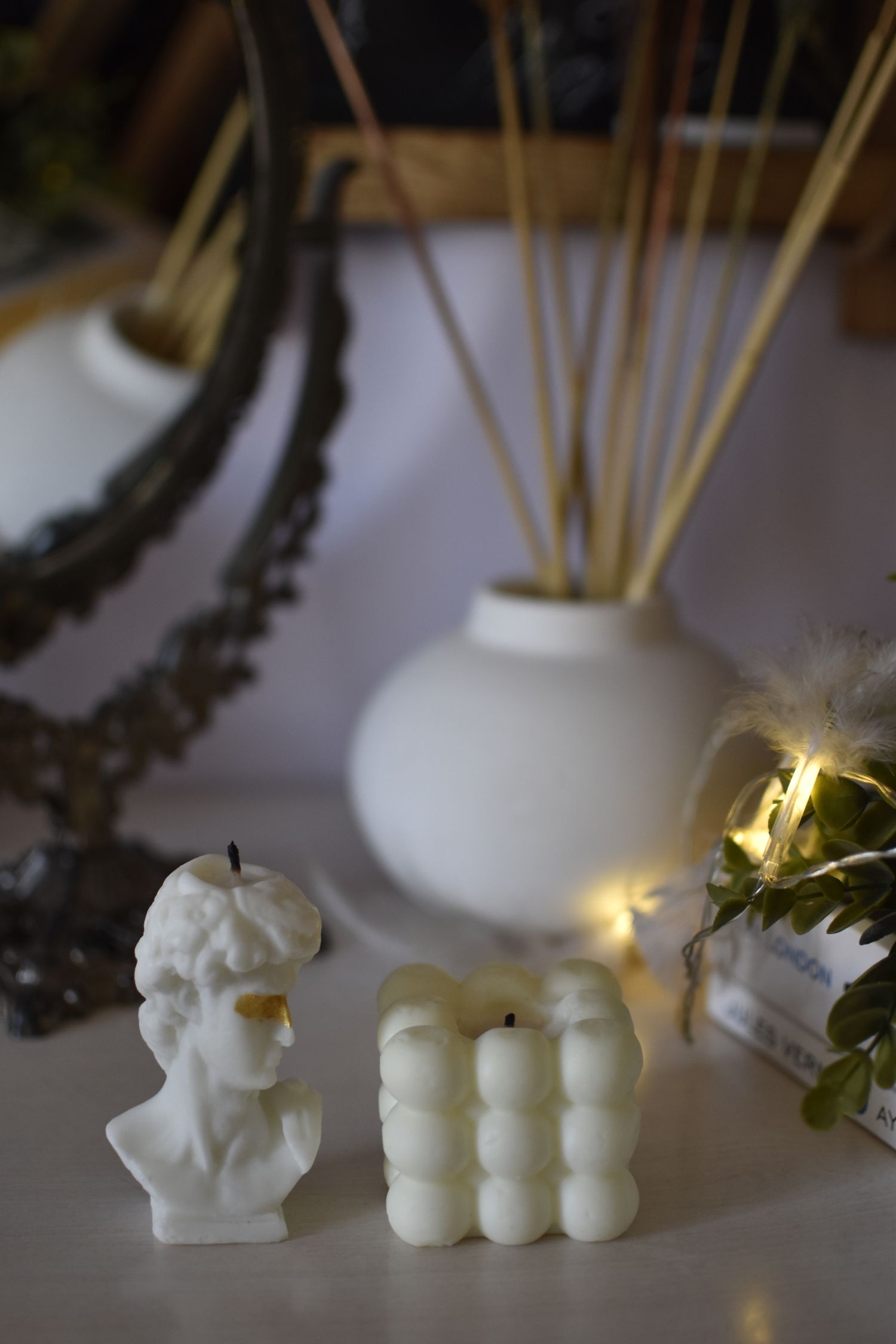 A styled seasonal display of sculptural candles and decor
